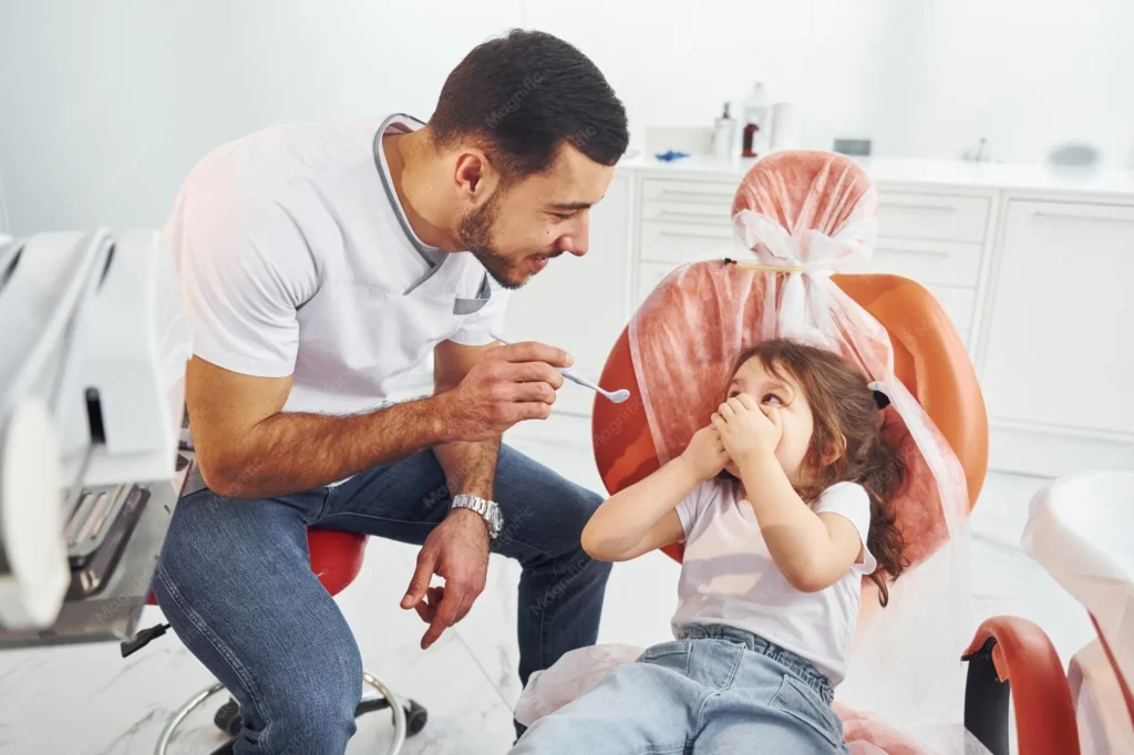 Pediatric dentist comforting a nervous child